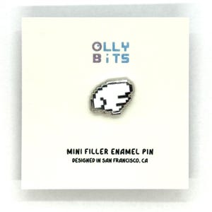 Puede incluir: Pin de esmalte blanco y plateado con un dise&ntilde;o pixelado en forma de nube. El pin est&aacute; sobre una tarjeta blanca con el texto "Olly Bits" y "Mini Filler Enamel Pin Designed in San Francisco, CA."