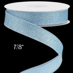 May include: A spool of light blue glitter ribbon, 7/8 inch wide, against a black background. The ribbon is rolled on a white cardboard spool. The ribbon is a solid color with a glittery texture.