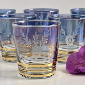 May include: Set of six iridescent blue glass tumblers with gold trim and etched floral designs.