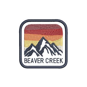 Peut inclure: Un écusson brodé bleu marine sur fond blanc. L'écusson représente une chaîne de montagnes avec un coucher de soleil derrière. Le texte "BEAVER CREEK" est imprimé en blanc sous les montagnes.