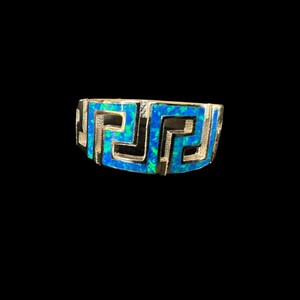 Könnte beinhalten: Ein silberner Ring mit einem blauen Opal-Inlay in einem griechischen Schlüsselmuster.
