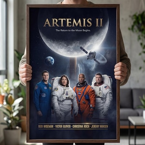 May include: A framed poster featuring the Artemis II mission. The poster displays the text "ARTEMIS II" above an image of the moon, Earth, and a spacecraft. Four astronauts in space suits are positioned below. The names of the astronauts are listed at the bottom.