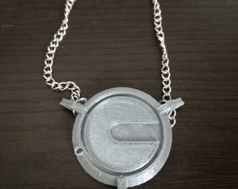May include: A silver chain necklace with a pendant featuring a stylised letter C in a circular design.
