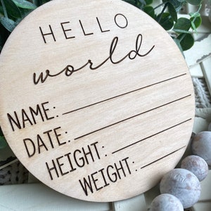 May include: A round wooden sign with the text "HELLO world" and blank lines for "NAME", "DATE", "HEIGHT", and "WEIGHT".