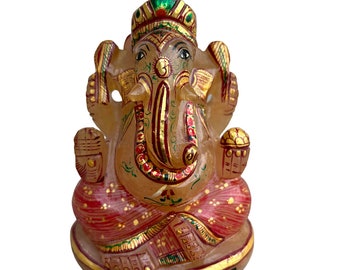 May include: A hand-painted, orange-colored, stone statue of the Hindu deity Ganesha. The statue is decorated with gold and red paint and features intricate details.