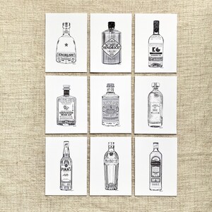 May include: Nine black and white illustrations of different gin bottles on white cards. The bottles are labeled with the names of the gins, including Caorunn, Hendrick's, Tanqueray, Gunpowder Irish Gin, Jawbox, Plymouth, and Beefeater.