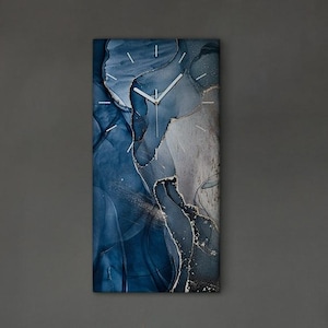 Könnte beinhalten: Abstrakte Wandkunst in Blau-, Grau- und Silbertönen. Die rechteckige Leinwand ist an einer dunkelgrauen Wand befestigt. Ein weißes Regal zeigt Glasflaschen, Pflanzen und Weingläser. Eine Kaffeemaschine und ein Schild mit der Aufschrift "GOOD MORNING" stehen auf einem Holzschrank.
