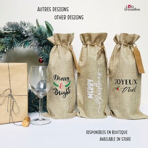 以下が含まれることがあります： クリスマスの刺繍が施された、麻製のワインボトル用ギフトバッグが3つ。バッグは白い表面に並べて置かれています。バッグには、「メリー＆ブライト」、「メリークリスマス」、「ジョワイユ・ノエル」の文字が刺繍されています。