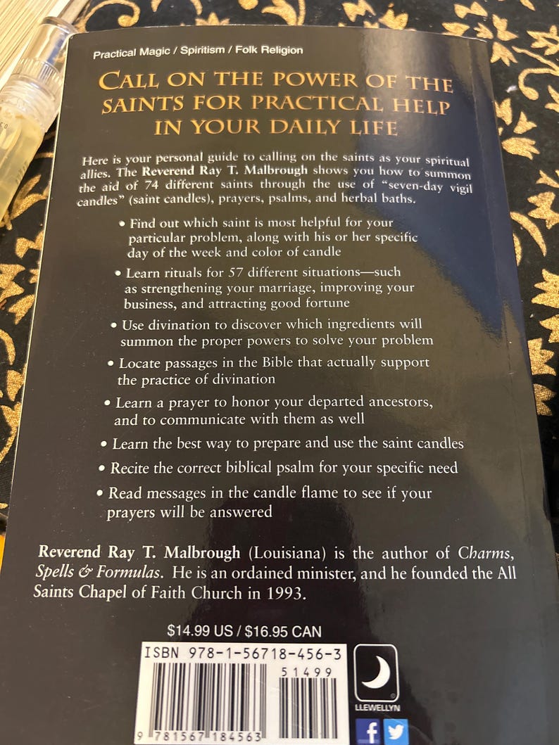 May include: A paperback book titled "Call on the Power of the Saints for Practical Help in Your Daily Life." The cover features text about spiritual allies, rituals, and divination. The author is Reverend Ray T. Malbrough.