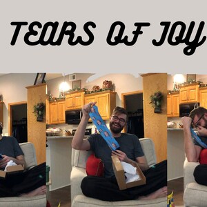 May include: A person is sitting on a couch and holding a pair of socks with a face printed on them. The person is laughing and appears to be very happy. The text "Tears of Joy" is written above the image.