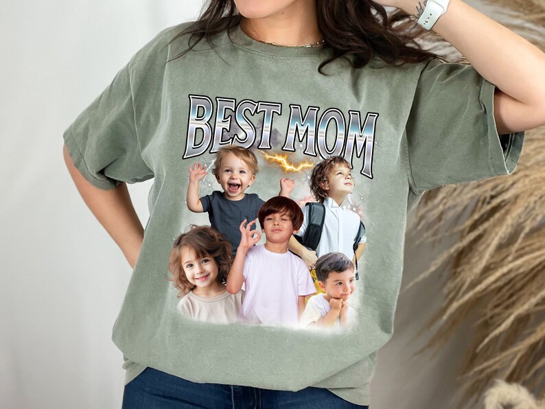 K&ouml;nnte beinhalten: Ein gr&uuml;nes T-Shirt mit dem Text "BEST MOM" in silbernen Buchstaben. Das Shirt zeigt eine Collage aus f&uuml;nf Kindergesichtern.