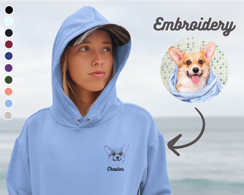 Peut inclure: Un sweat &agrave; capuche bleu clair avec une image brod&eacute;e en noir et blanc d'un chien avec le nom "Chester" en dessous. Le sweat &agrave; capuche a une capuche avec cordon de serrage et une poche kangourou.