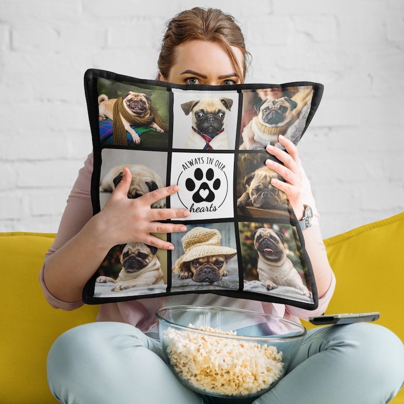 May include: Square pillow with a black border featuring a collage of pug images. The center square has a paw print and heart design with the text "ALWAYS IN OUR hearts". The pillow is held by a person.
