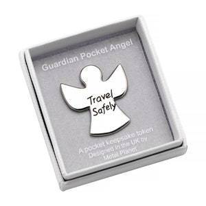 Può includere: Un ciondolo da tasca angelo custode in argento in una scatola bianca. L'angelo ha le parole "Travel Safely" incise su di esso. La scatola ha le parole "Guardian Pocket Angel" stampate su di essa.