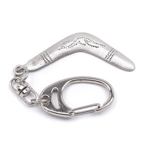 May include: Silver-colored boomerang keychain with a decorative pattern and a sturdy metal clasp. The keychain is designed with a swivel base and a carabiner-style clip for easy attachment to keys or bags. The boomerang is approximately 2 inches long.