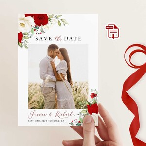 K&ouml;nnte beinhalten: Eine Save-the-Date-Karte mit einem Foto eines Paares, umrahmt von roten und wei&szlig;en Blumen. Der Text "SAVE the DATE" steht oben, mit den Namen "Jessica & Richard" und dem Datum darunter. Die Karte wird von einer Hand gehalten.