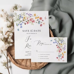 May include: Save the date card with watercolor floral design. The card features a floral garland with pink, blue, and yellow flowers. The text reads "Save the Date for the Wedding of Je, Ries" and "Sept 14th, 2021".