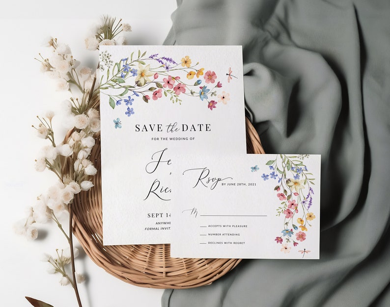 May include: Save the date card with watercolor floral design. The card features a floral garland with pink, blue, and yellow flowers. The text reads "Save the Date for the Wedding of Je, Ries" and "Sept 14th, 2021".