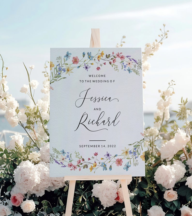 May include: A wedding welcome sign with a floral border. The sign reads "Welcome to the wedding of Jessica and Richard, September 14, 2022".