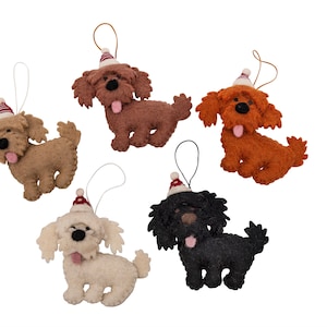 May include: Five felt dog ornaments with red and white Santa hats. The dogs are brown, orange, white, and black.