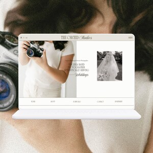May include: A website homepage for The Orchid Studios, a Virginia-based photographer specializing in weddings. The website features a black and white photo of a bride in a wedding dress and veil, and text that reads "Virginia Based Photographer Authentically Serving Weddings".