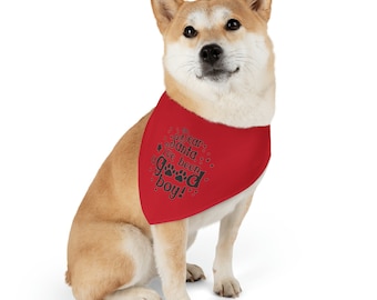 May include: A red triangular pet bandana featuring the black text Dear Santa I've been good boy with paw print accents. The bandana is worn around the neck of a tan and white Shiba Inu dog sitting in a forward-facing position.