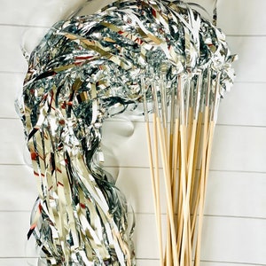 May include: A bundle of silver streamer wands with wooden sticks. The streamers are curled and ready to be used for party decorations.