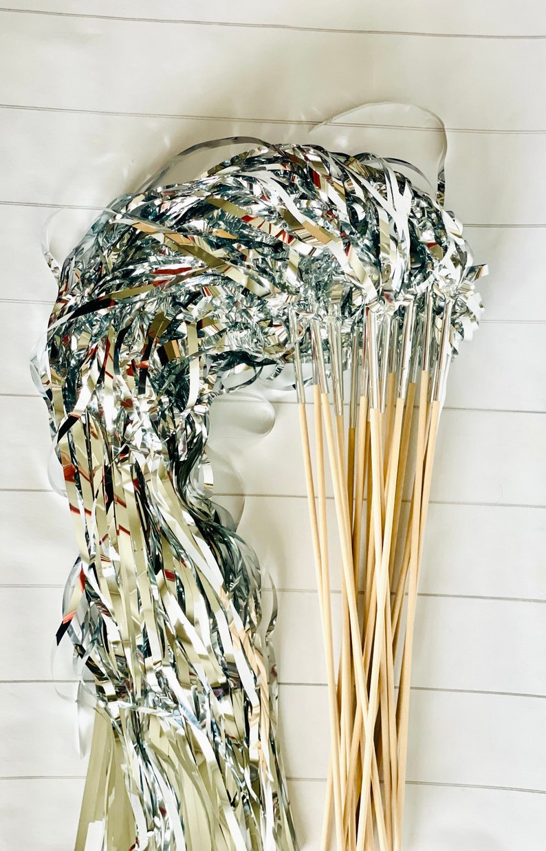 May include: A bundle of silver streamer wands with wooden sticks. The streamers are curled and ready to be used for party decorations.