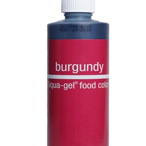 Peut inclure: Une bouteille de colorant alimentaire liqua-gel bordeaux avec un embout rouge et un bouchon blanc. L'étiquette indique "burgundy" et "Chefmaster". Le poids net est de 298g.
