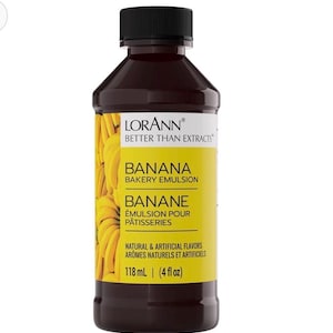 May include: A dark brown plastic bottle of LorAnn Banana Bakery Emulsion with a black screw-top cap. The yellow label features a banana graphic and text including "BANANA BAKERY EMULSION" and "118 mL (4 fl oz)" printed on the front surface.