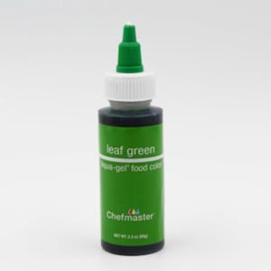 Peut inclure: Une bouteille de colorant alimentaire aqua-gel vert feuille de Chefmaster. La bouteille a un corps vert avec des accents blancs et verts. L'étiquette indique "leaf green" et "aqua-gel food color". Le poids net est de 65g.
