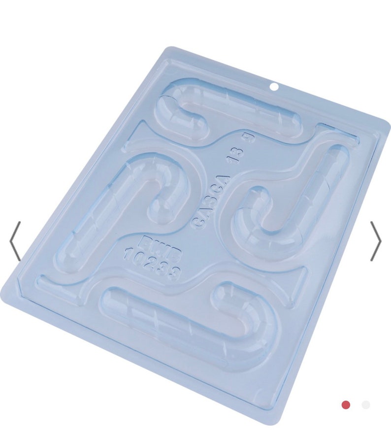 K&ouml;nnte beinhalten: Eine transparente Plastik-Bonbonform mit sechs Hohlr&auml;umen in Form von Zuckerstangen. Die Form ist hellblau und hat den Text "64564 13 9" aufgedruckt.