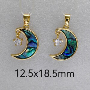 May include: Gold crescent moon pendant with a small star charm. The moon is made of abalone shell with a blue and green iridescent pattern. The pendant measures 12.5 x 18.5 mm.
