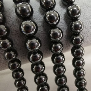 May include: A strand of black beads, likely made of onyx or hematite, with a smooth, polished finish. The beads are round and uniform in size, creating a classic and elegant look.