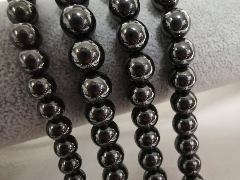 May include: A strand of black beads, likely made of onyx or hematite, with a smooth, polished finish. The beads are round and uniform in size, creating a classic and elegant look.