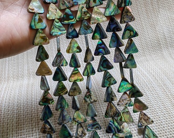 Peut inclure: Un brin de perles triangulaires en nacre d'ormeau irisée. Les perles sont d'un mélange de couleurs vertes, bleues et dorées.