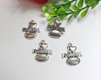 May include: Four silver-toned charms with the words "I Love Football" and a football-shaped pendant. Each charm has a heart above the word "Football". The charms are on a white surface with green and red floral accents.