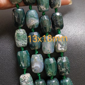 Puede incluir: Una hebra de cuentas de ágata verde con un patrón moteado. Las cuentas miden aproximadamente 13 mm x 18 mm y están enhebradas en un hilo verde.