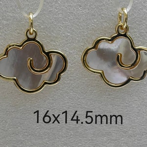 May include: Two gold-tone pendants shaped like clouds with a white mother-of-pearl inlay. The pendants measure 16 x 14.5 mm.