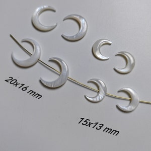 May include: A strand of white mother of pearl crescent moon beads. The beads are strung on a gold wire. The beads are 20x16 mm and 15x13 mm.