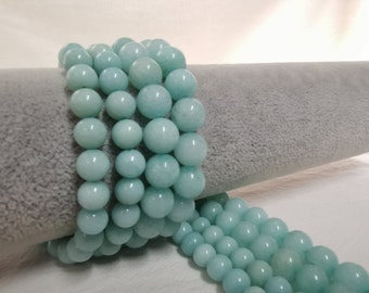 Peut inclure: Un brin de perles rondes bleu clair en aquamarine. Les perles sont enfilées sur un fil transparent et disposées en cercle.