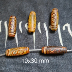 May include: Four brown and white agate beads with a brown 'S' carved into each bead. The beads are 10 mm in diameter and 30 mm long.
