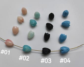 May include: A close-up of a string of beads with different colors and shapes. The beads are in four groups, labeled #01, #02, #03, and #04. The beads are pink, blue, and black.