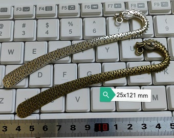 May include: Two silver and gold dragon bookmark with a scaly design. The bookmarks are 25 by 121 millimeters.