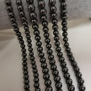 May include: Five strands of black hematite beads, each strand is approximately 18 inches long.