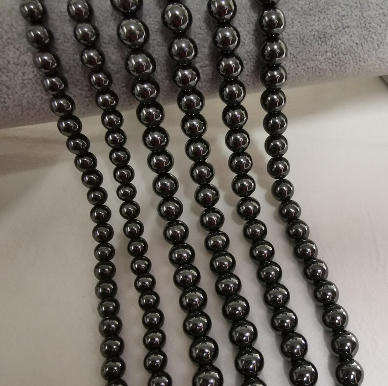 May include: Five strands of black hematite beads, each strand is approximately 18 inches long.