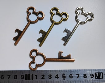 May include: Four antique-style key-shaped bottle openers with Mickey Mouse ears. The bottle openers are made of metal and come in three different finishes: copper, gold, and silver.