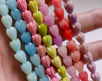 May include: A strand of colorful heart-shaped beads in shades of blue, green, pink, and purple. The beads are made of a smooth, polished material and have a delicate, floral design.