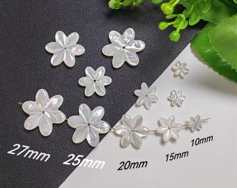 May include: A collection of white iridescent mother-of-pearl flower-shaped beads with central holes. The beads are arranged in various sizes labeled as 27mm, 25mm, 20mm, 15mm, and 10mm, with some strung on a thin wire, showcasing a smooth, glossy finish.