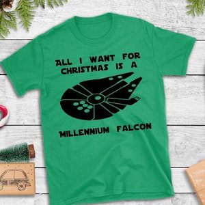 May include: Green t-shirt with a black graphic of the Millennium Falcon spaceship and the text "All I want for Christmas is a Millennium Falcon".